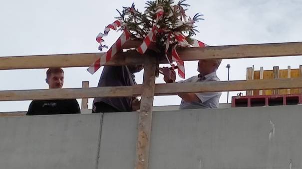 Robert Oberndorfer, Geschäftsführer CS Caritas Socialis, beim Befestigen des Firstbaumes.